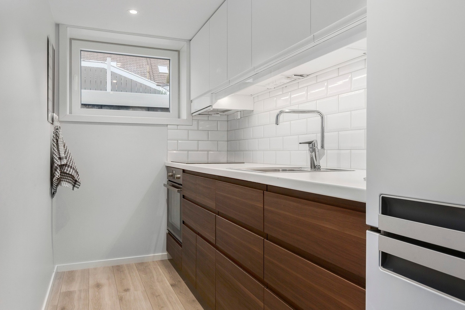 Pent kjøkken fra Ikea med integrerte hvitevarer som stekeovn, platetopp og oppvaskmaskin. Galleribilde