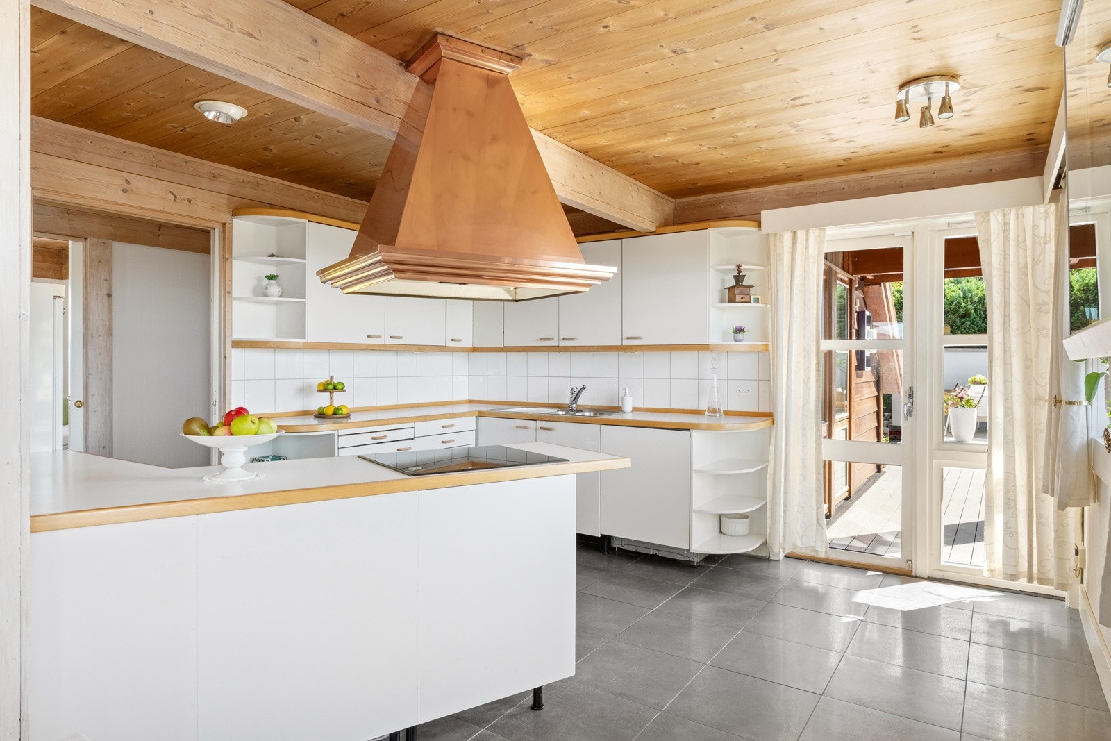 Innredningen har videre slette, hvite fronter og benkeplate av slitesterk laminat med nedfelt vask av stål. Galleribilde