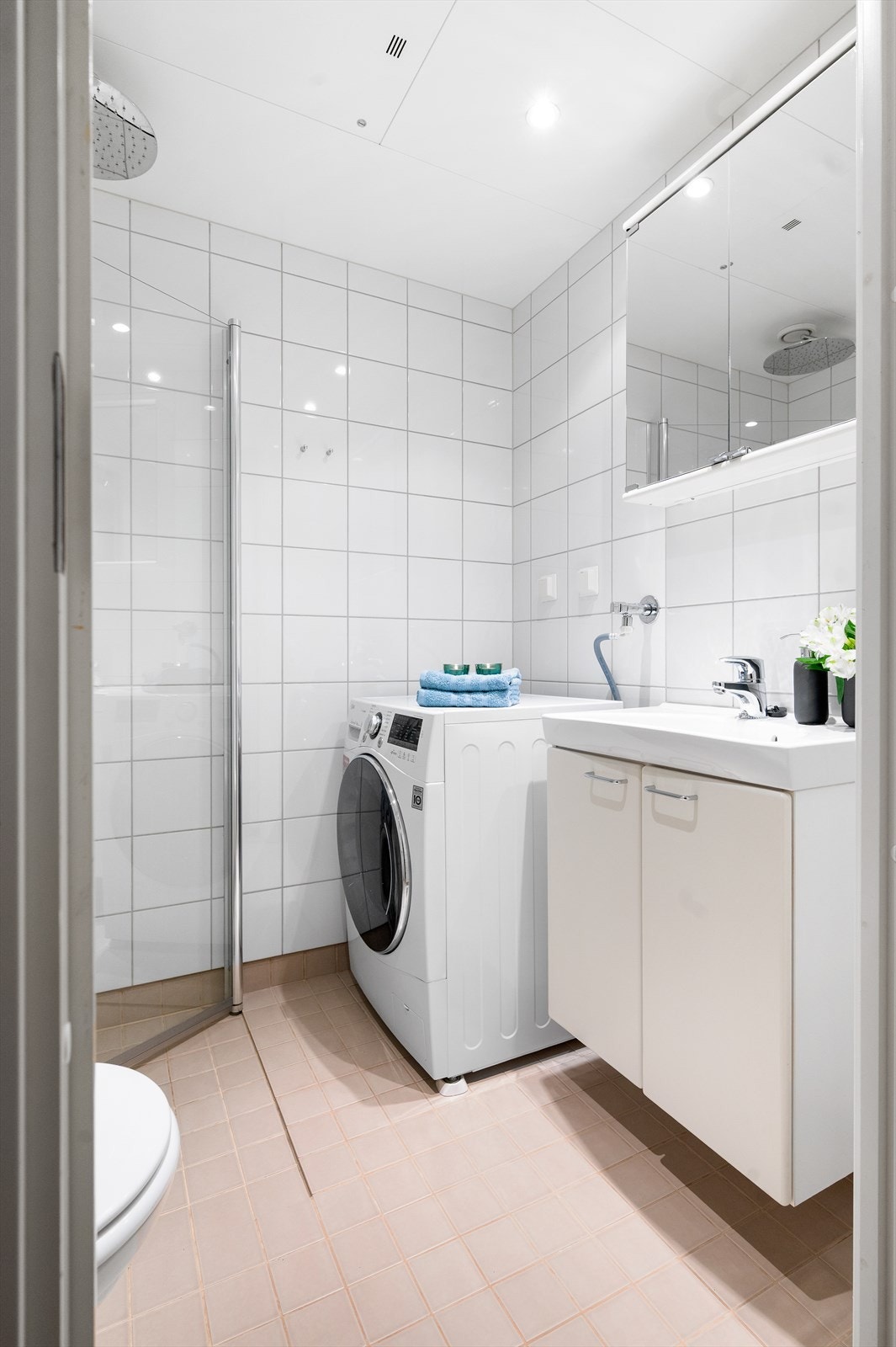Videre har badet vegghengt toalett og dusjhjørne med innfellbare dører av glass og dusjarmatur tilkoblet hånddusj og regndusj. Opplegg for vaskemaskin og mekanisk avtrekksventil plassert i himling. Galleribilde