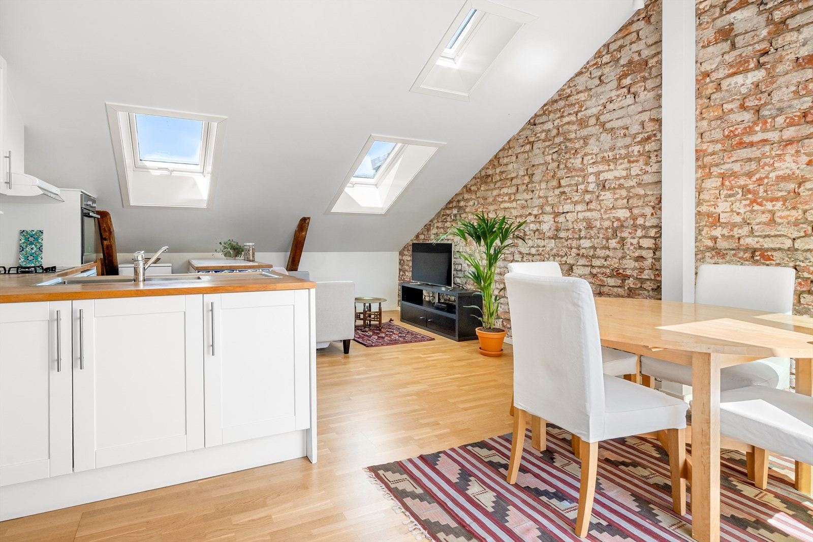 Den åpne løsningen oppleves romslig med plass til både sofaseksjon og spisebord. Galleribilde