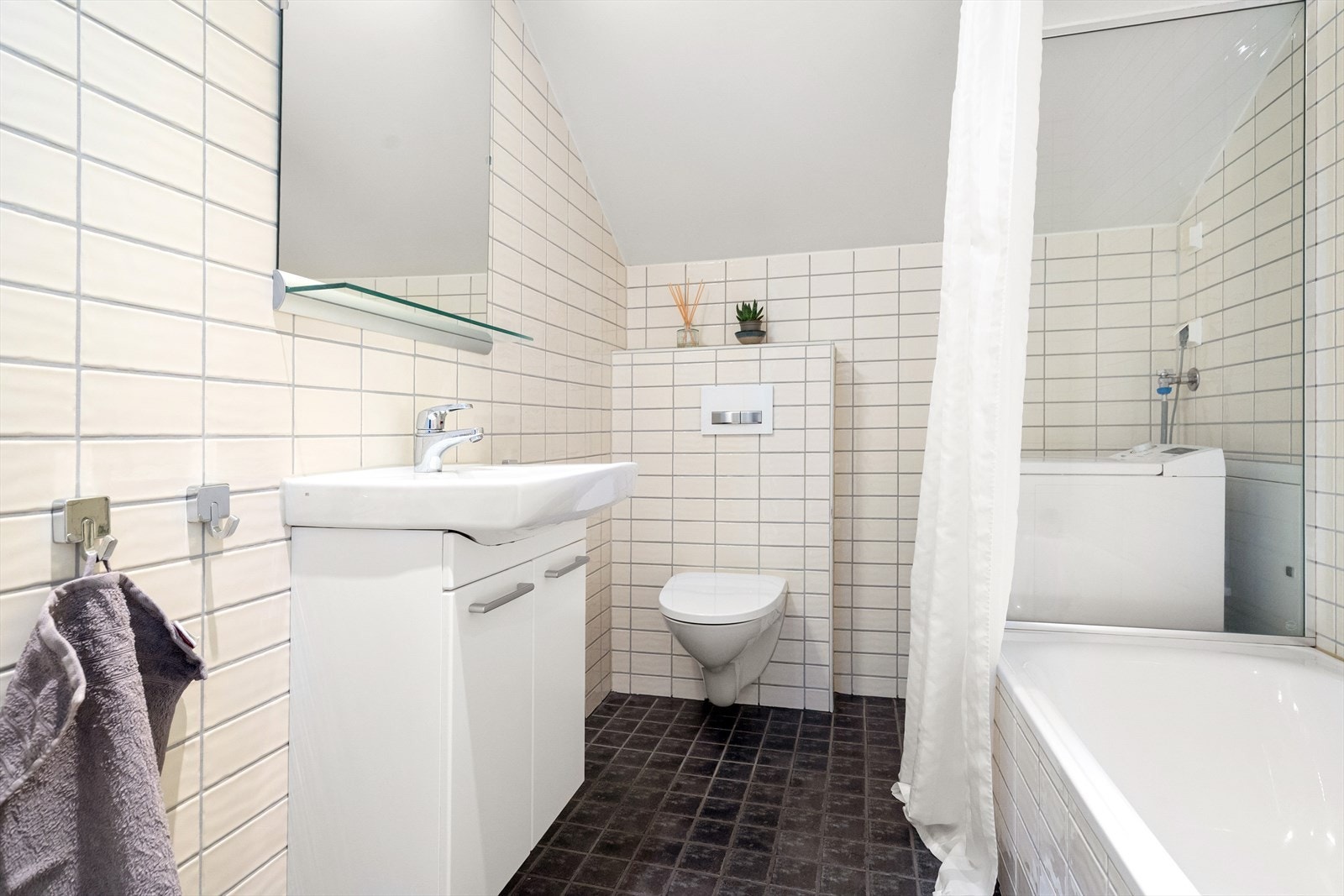 Pent, flislagt bad med opplegg til vaskemaskin. Galleribilde