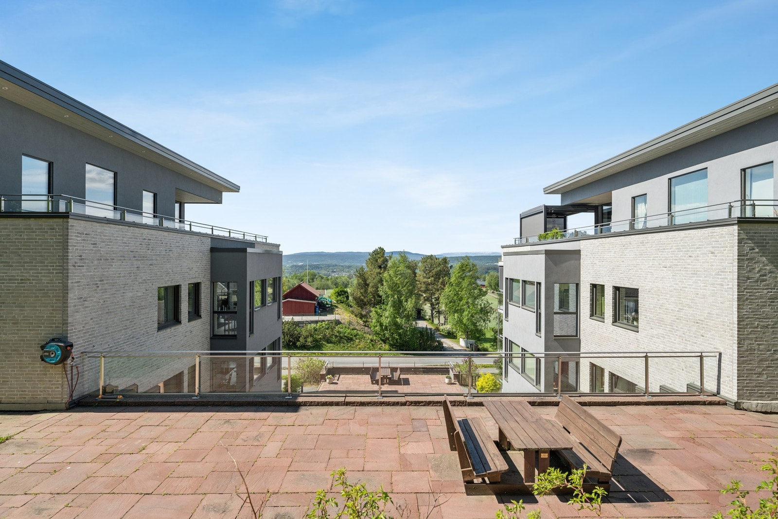 Felles, solrik uteplass med sittegruppe - et hyggelig uteområde for beboerne med flott utsikt og grønne omgivelser. Galleribilde