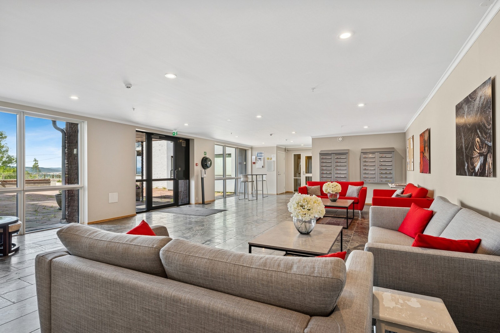 Velholdt og innbydende felles inngangsparti med sittegrupper, postkassestativ og heis til alle etasjer. Galleribilde