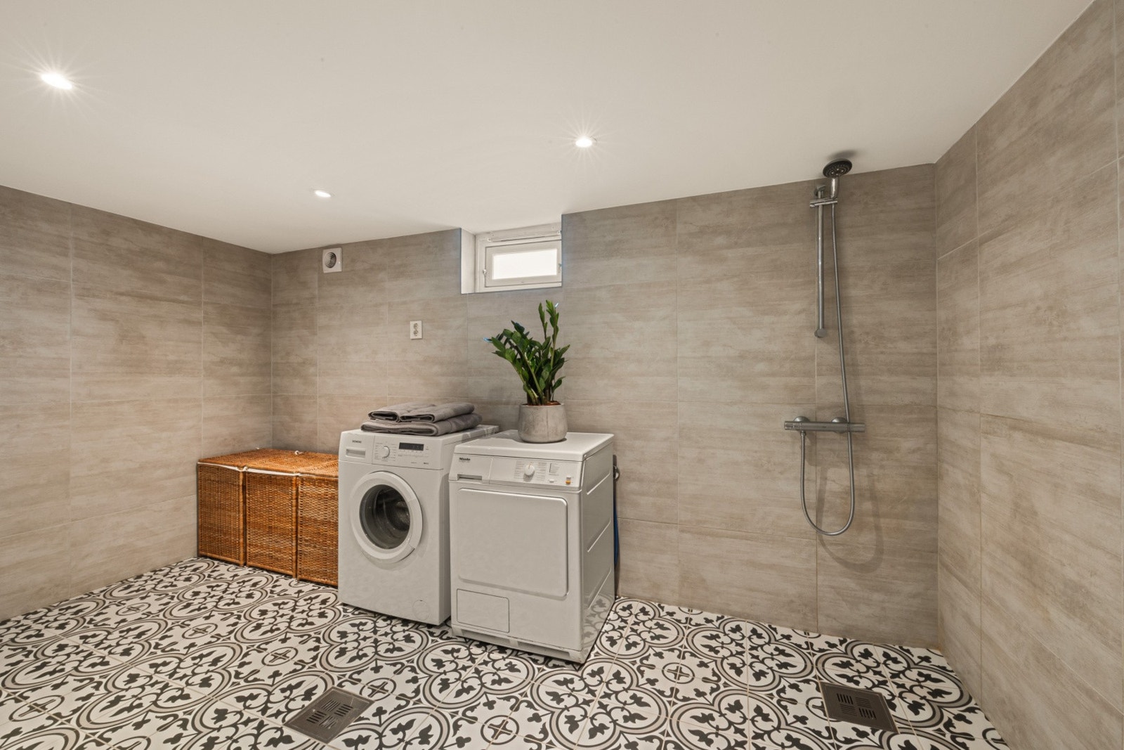 Stort, lekkert vaskerom/bad fra 2017 med klassiske fliser på gulvet og lune farger. Galleribilde