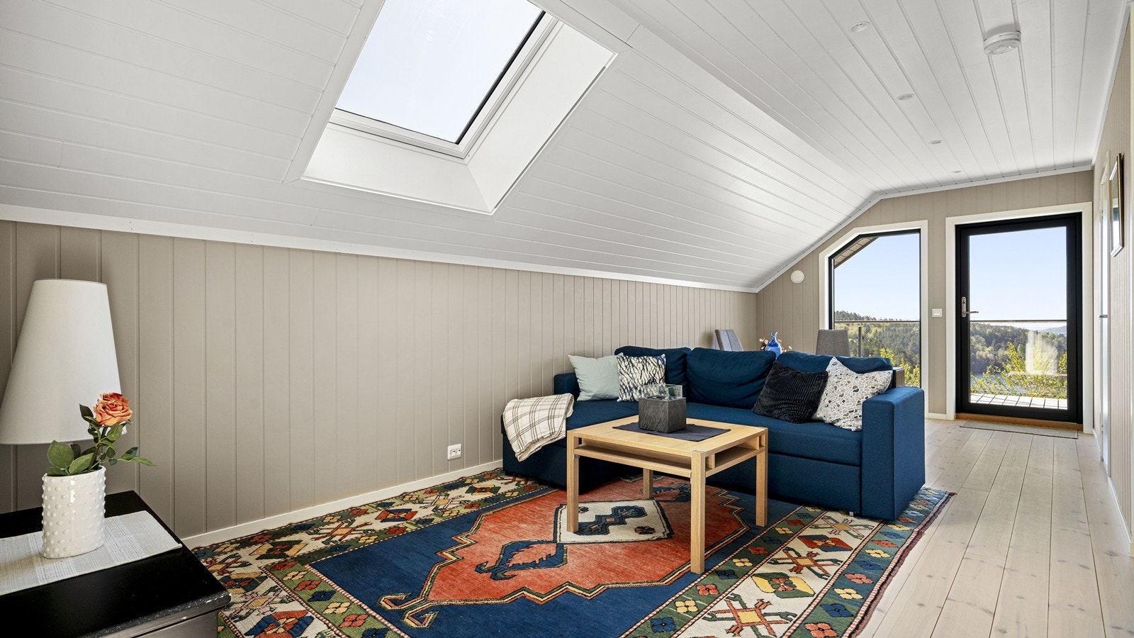 Lys og romslig loftstue med god plass til sofa og tv med tilhørende møblement Galleribilde