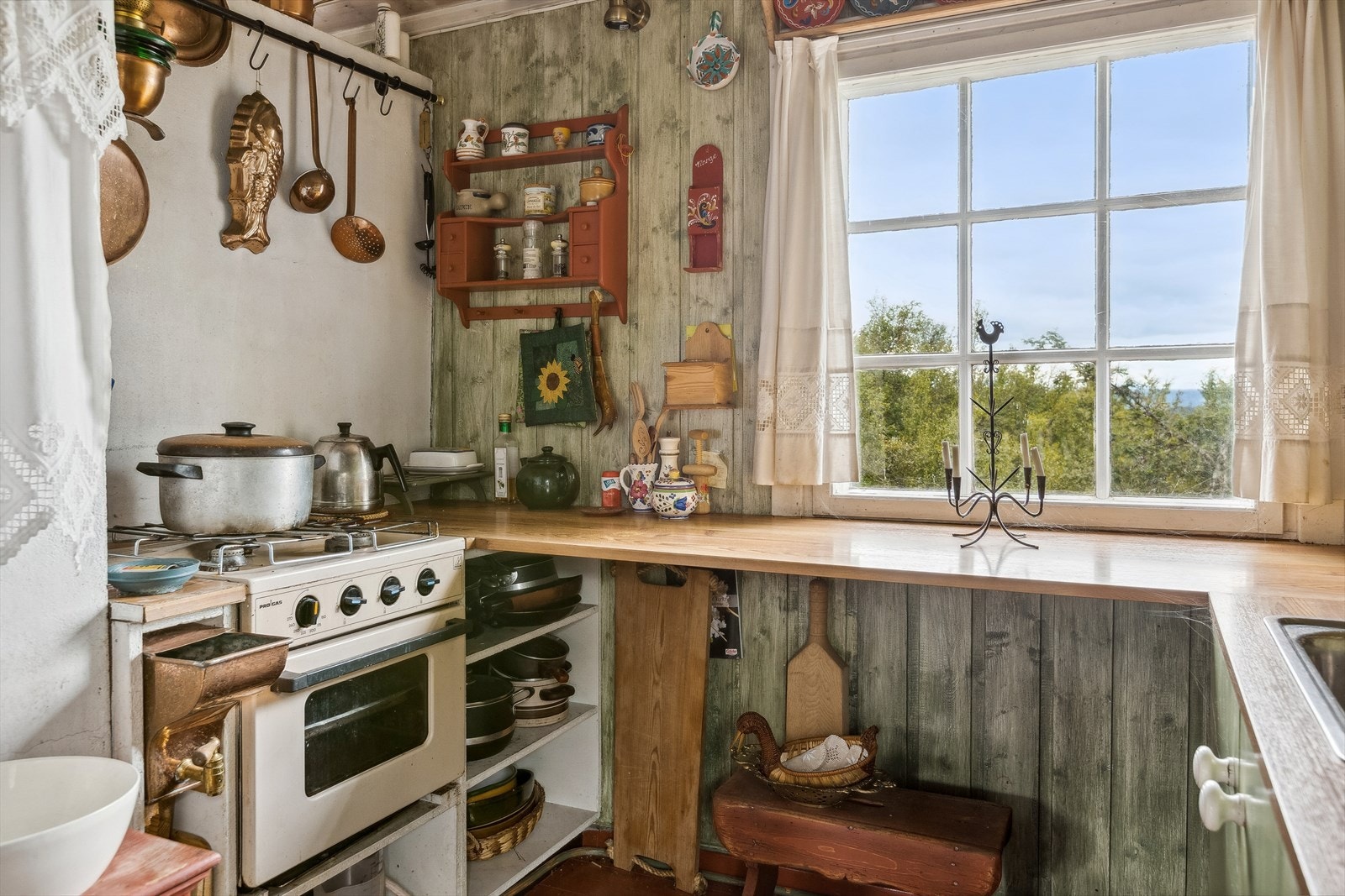 . Kjøkkenet har enkel innredning med over- og underskap. Det er bra med benkeplass og nedfelt oppvaskkum med avløp til terreng. Frittstående gasskomfyr. Galleribilde