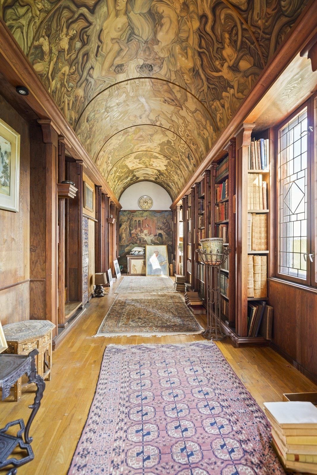 Flott bibliotek med snekkerbygde bokhyller og buet himling. Galleribilde