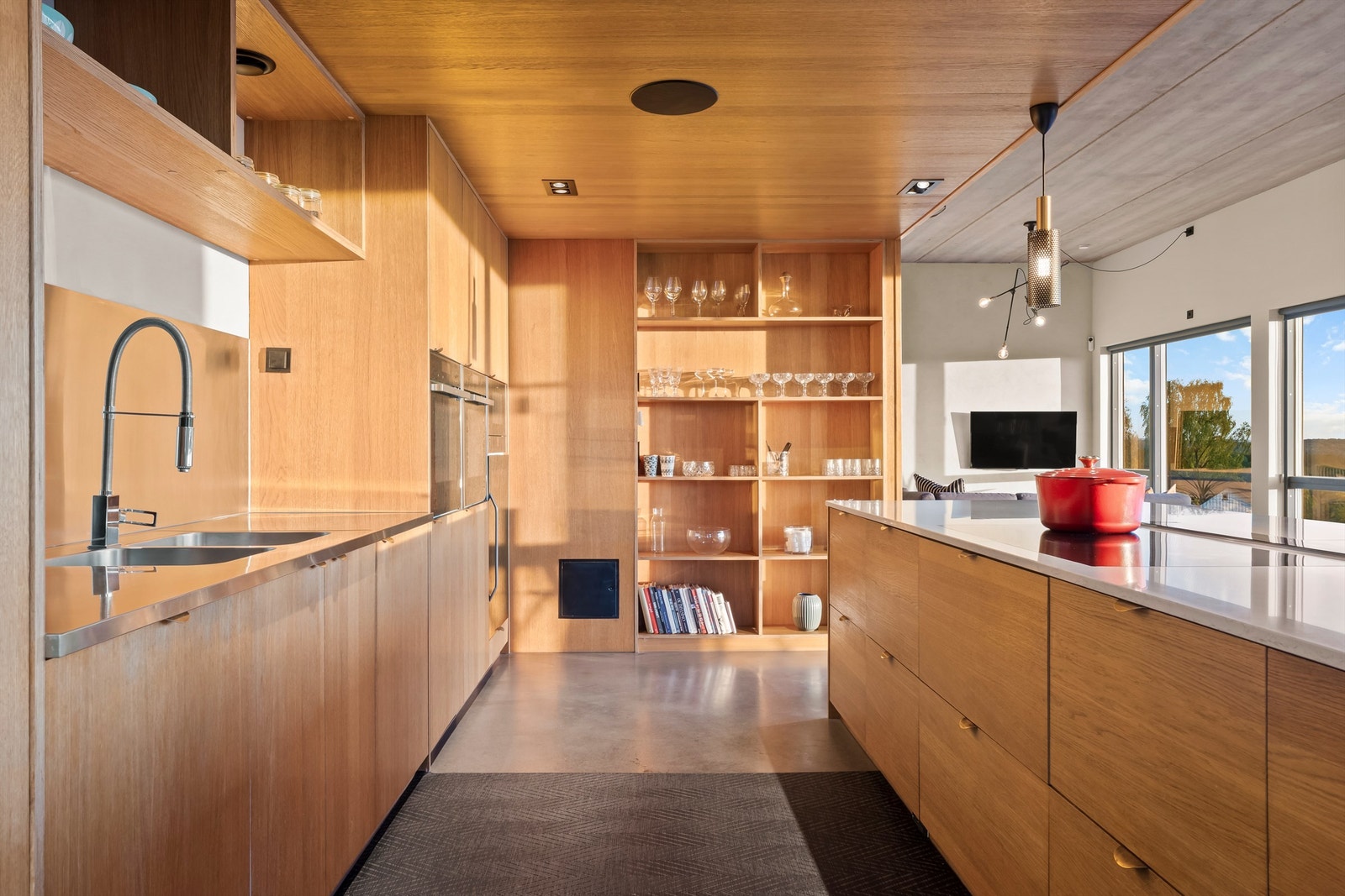 Spesialbygget hylleløsninger i eikefiner, integrert lydsystem fra Hifi klubben med innebygget diskant og integrerte hvitevarer Galleribilde