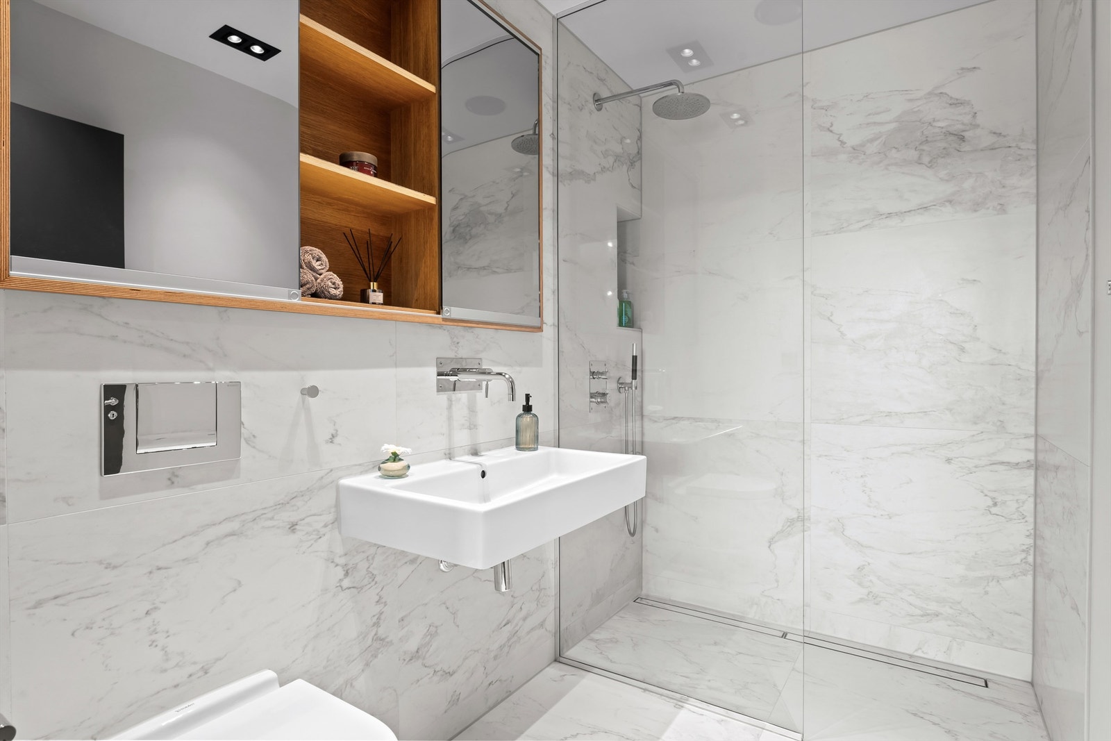 B A D - Delikat flislagt baderommet med store fotoprintet fliser på gulv og vegger, vannbåren gulvvarme og dimmbare downlights i himlingen. Galleribilde