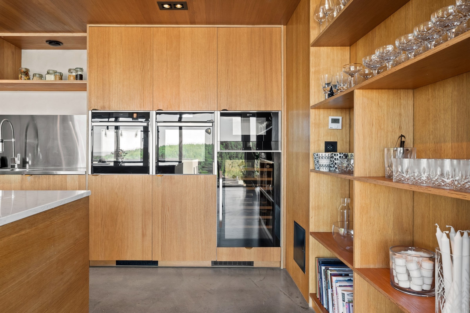 Kjøkkenet har Integrerte hvitevarer som kjøleskap og fryser i full høyde, oppvaskmaskin, stekeovn, steam ovn, mikrobølgeovn og vinkjøler Galleribilde