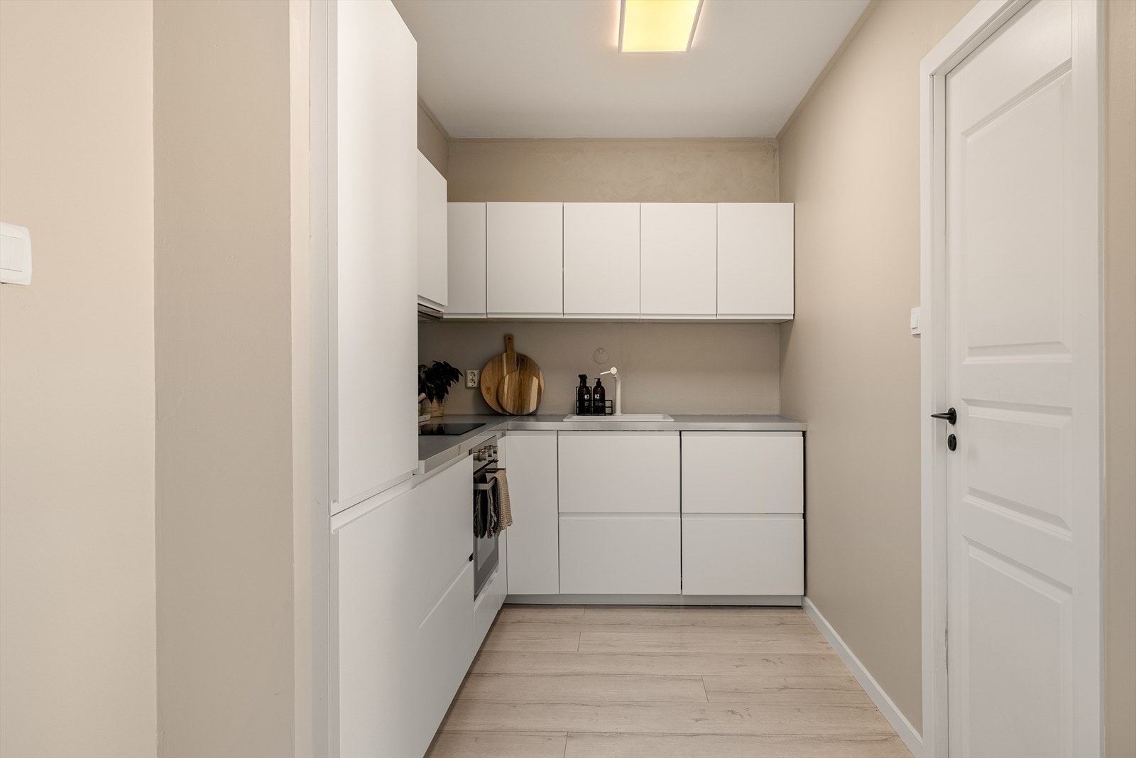 Lekker kjøkkeninnredning fra IKEA med hvite glatte fronter og laminert benkeplate med planlimt kjøkkenbeslag. Galleribilde