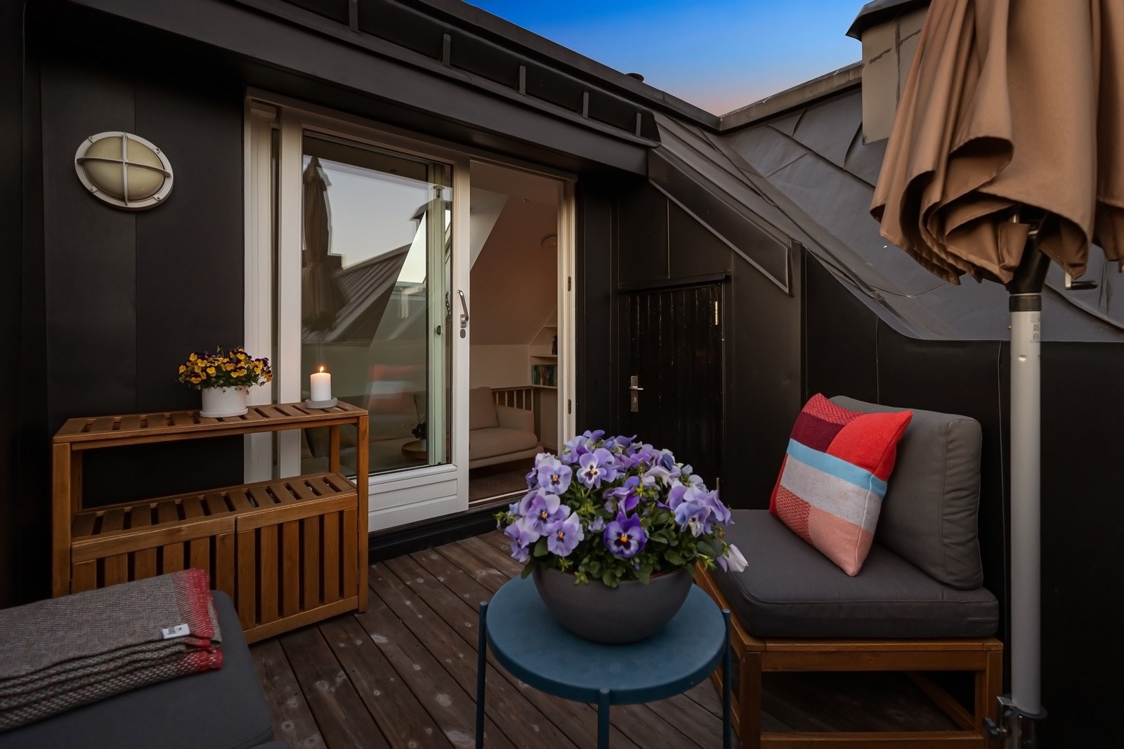 Uteplassen ligger usjenert til og er kledd med terrassebord og rekkverk av stål Galleribilde