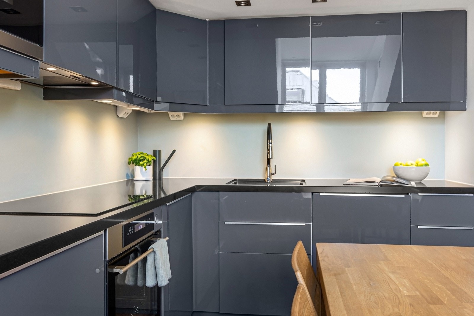 Godt med belysning over kjøkkenbenken og mye lagringsplass i skuffer og skap Galleribilde