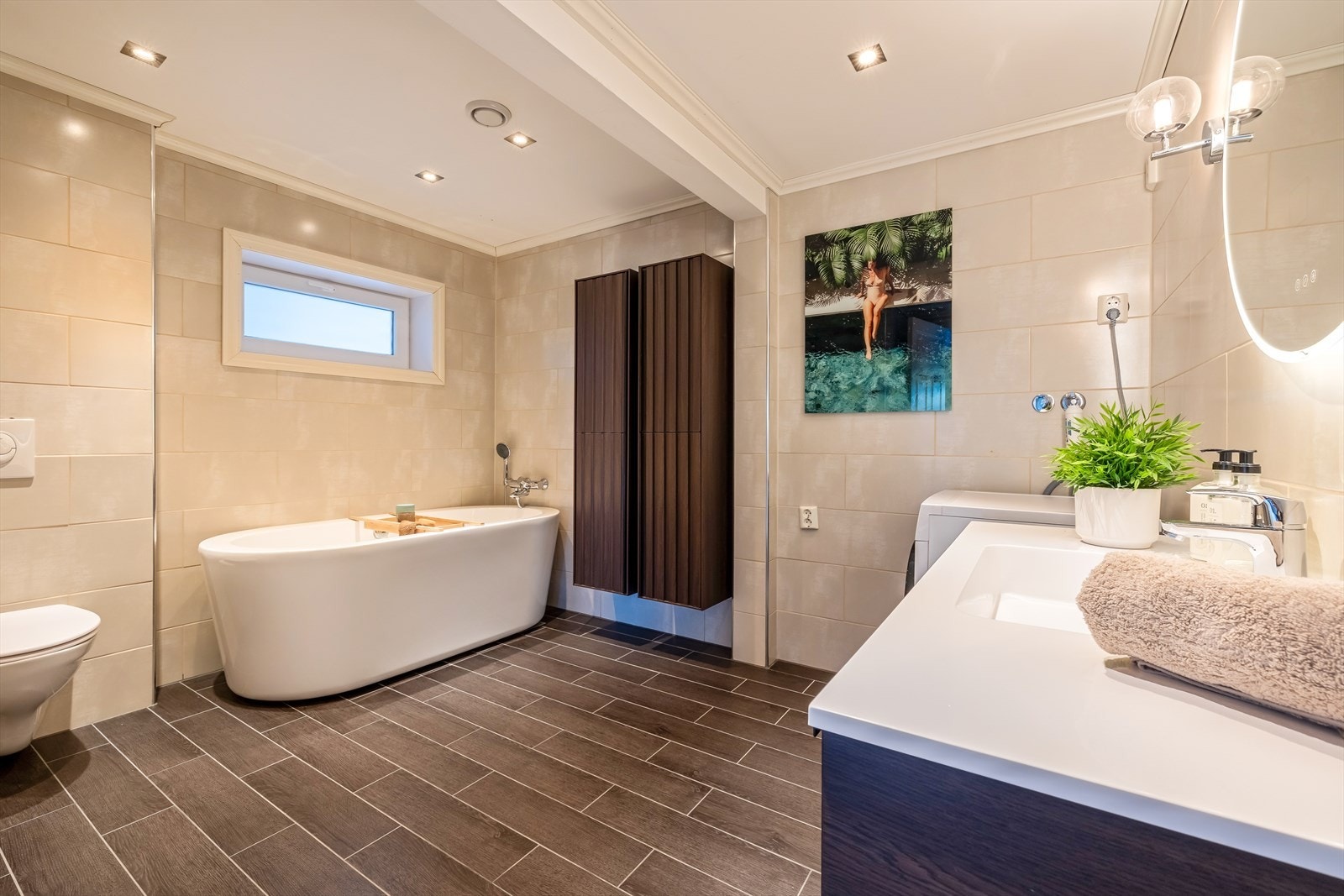 Badet er innredet med vegghengt toalett, dusj, badekar og servant møblement med speil. Det er også opplegg for vaskemaskin! Galleribilde