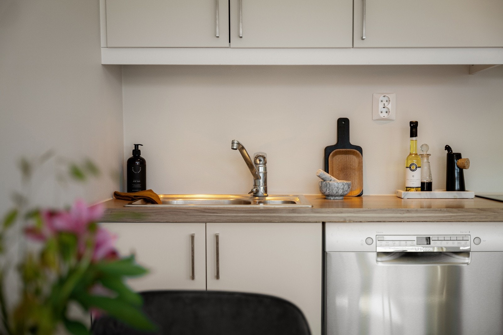 Lekkert og funksjonelt kjøkken med moderne ettgrepskran, integrerte hvitevarer og praktisk dobbel vask. Galleribilde