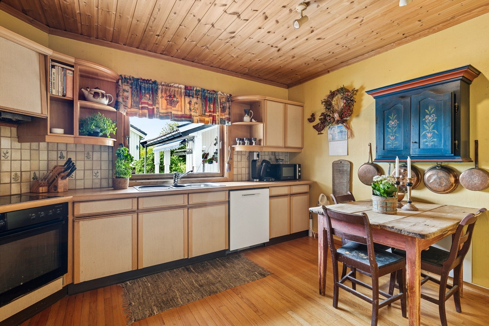 Et sjarmerende, eldre kjøkken som fortsatt er fullt funksjonelt. De klassiske skapene og den robuste benkeplaten gir en nostalgisk følelse, mens moderne apparater sikrer at matlagingen går som en drøm Galleribilde