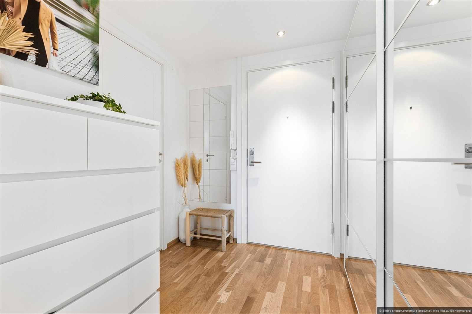 Lys og innbydende entré innredet med stor innebygd skyvedørsgarderobe. Galleribilde