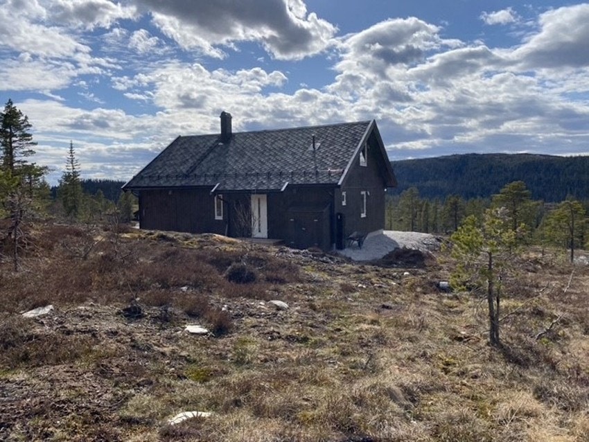 Hytta har et delvis overbygd inngangsparti, og en redskapsbod ved siden av. Galleribilde