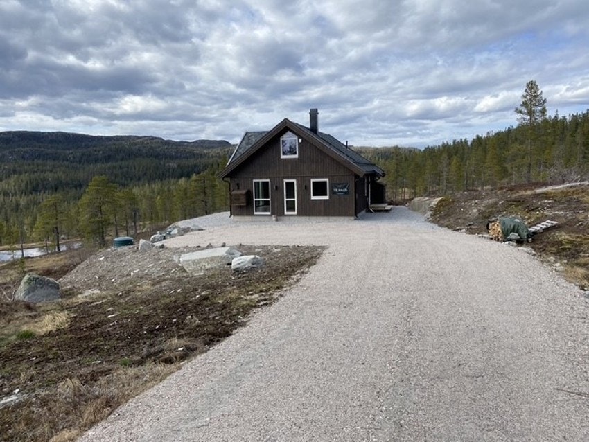 Det er opparbeidet gårdsplass med parkering rett utenfor hytta, som ellers omkranses av naturtomt og vakker fjellnatur med skog. Galleribilde