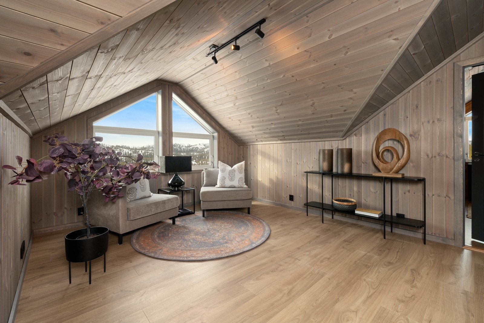 Loftstuen er et nydelig rom med mønevinduer som gir fantastisk utsikt til landskapet og solnedgangen. Galleribilde