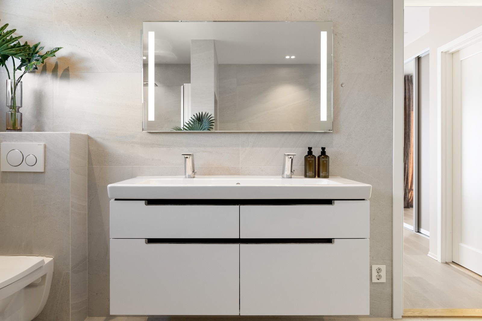 Innredningen består av en dobbel servant, veggmontert toalett, dusjnisje og et innmurt badekar. Galleribilde