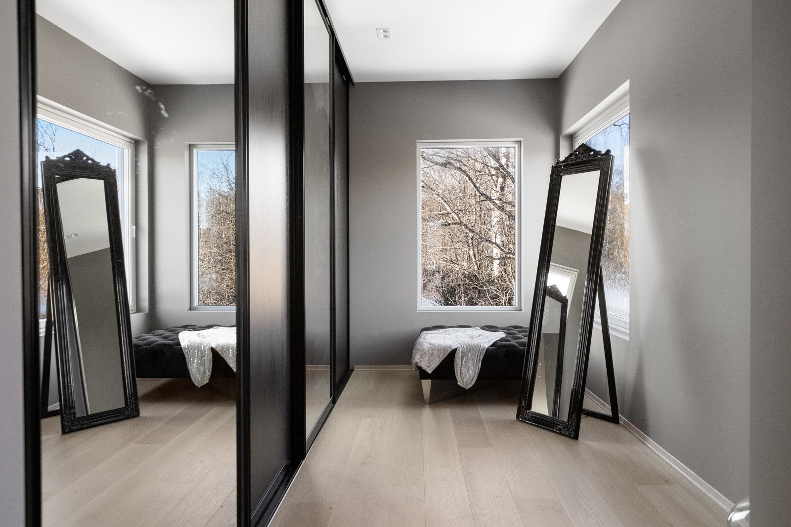 Walk-in closet med skyvedørsgarderobe og flere vindusflater. Galleribilde