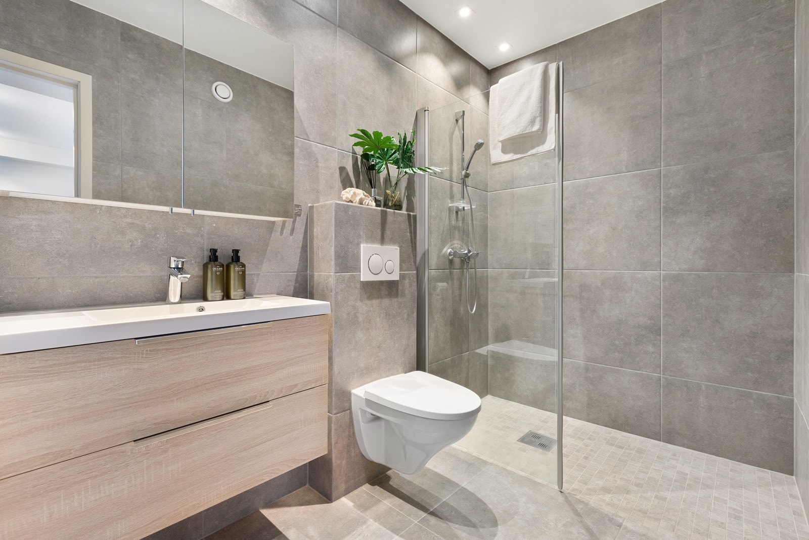 Bad med elektriske varmekabler, flislagte vegger og gulv, samt et malt tak. Her er det opplegg for vaskemaskin og god plass til tørketrommel. Galleribilde