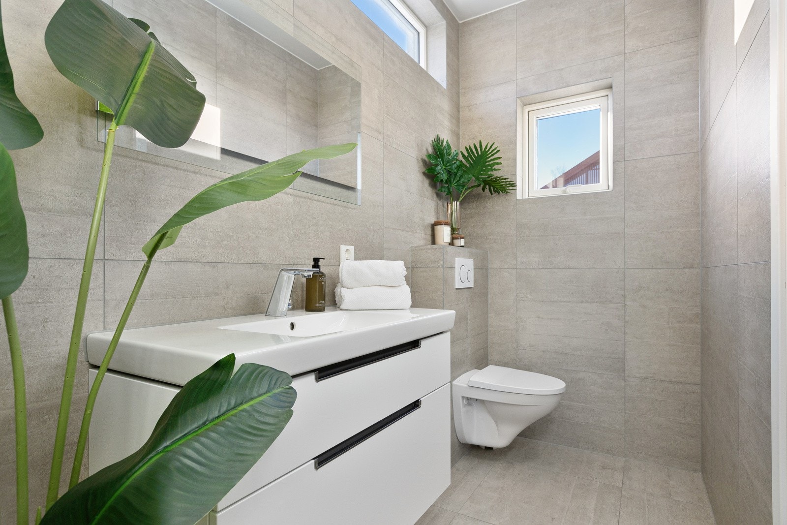 Gjennom skyvedørsgarderoben i entréen er det inngang til et lyst og delikat bad som kombinerer funksjonalitet med stil. Galleribilde