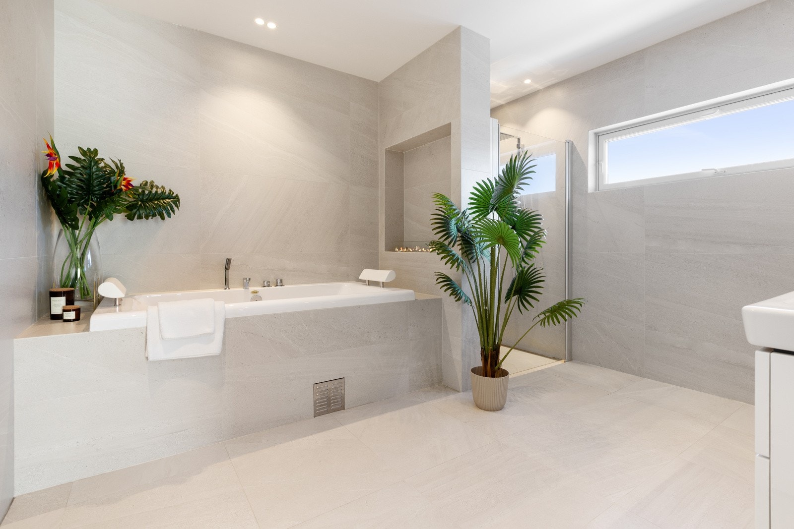 Gulvet og overflatene er flislagt med elegante fliser, mens taket er malt og utstyrt med downlights som gir et behagelig lys. Gulvvarme bidrar til ekstra komfort. Galleribilde