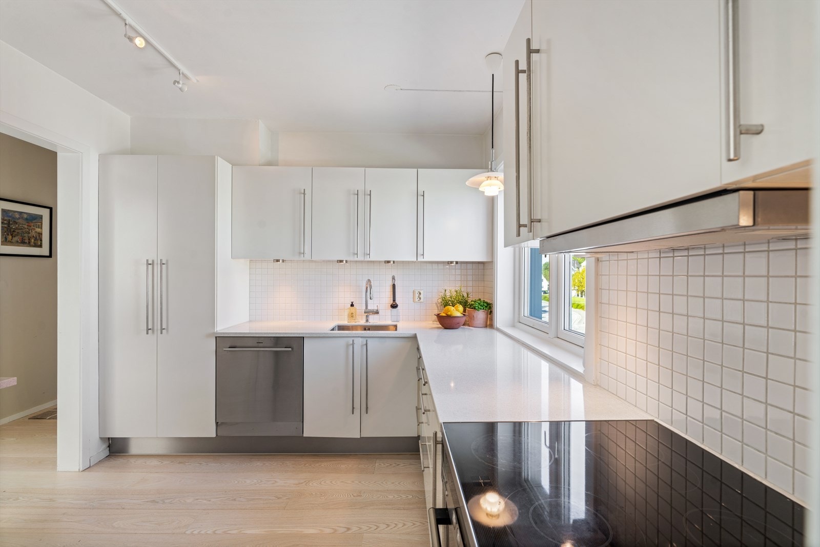 Det smakfulle HTH-kjøkkenet ble oppgradert i 2022 med en vedlikeholdsvennlig benkeplate i komposittstein fra Silestone, ny vask og armatur, samt praktisk LED-belysning over kjøkkenbenken. Galleribilde