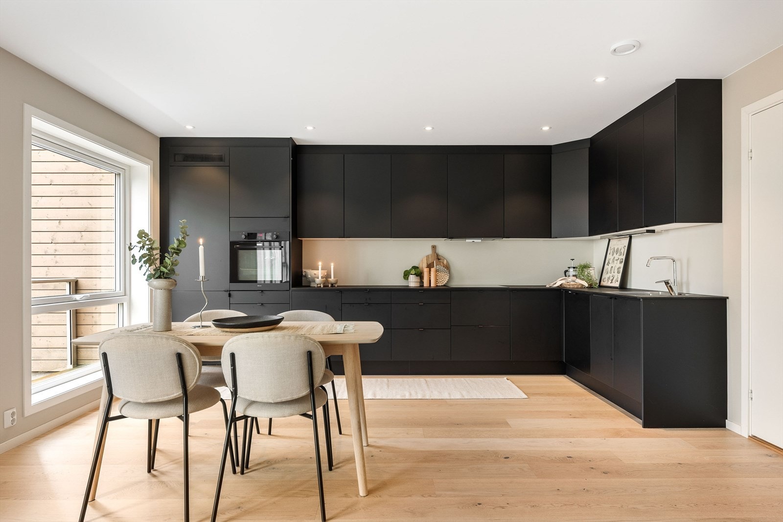 Mørk, laminert benkeplate med gode arbeidsflater, nedfelt platetopp og oppvaskkum i rustfritt stål med ett-greps blandebatteri. Galleribilde