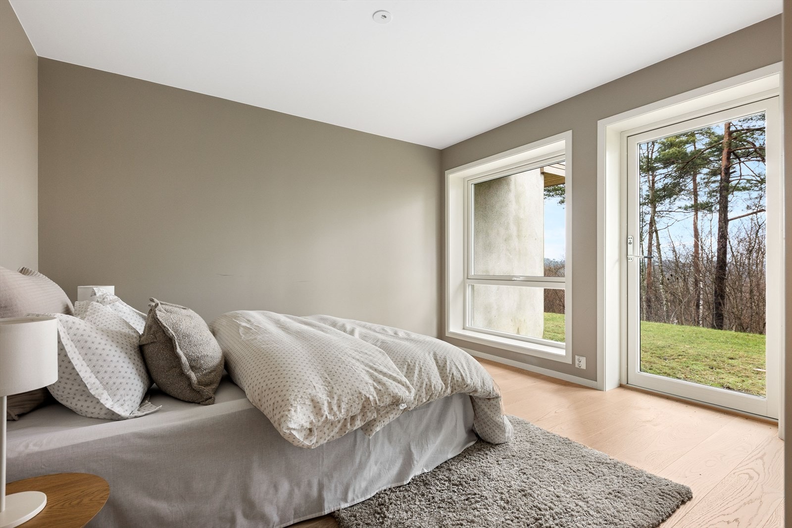 Det største av de to soverommene i underetasjen er av god størrelse, med god plass til soveromsmøblement og verandadør til felles plen. Galleribilde