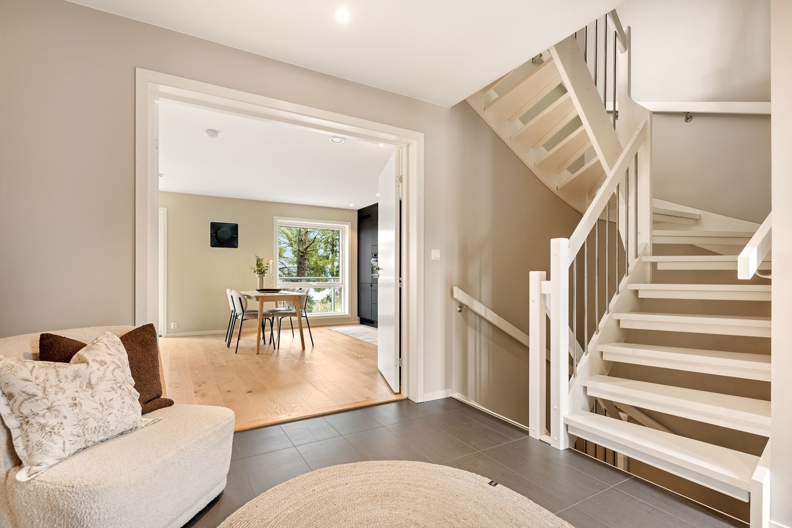 Stor, innbydende entré med varmekabler og flislagt gulv, samt innfelte downlights i tak. Tofløyet dør til stuen og malt trapp mellom etasjene. Galleribilde