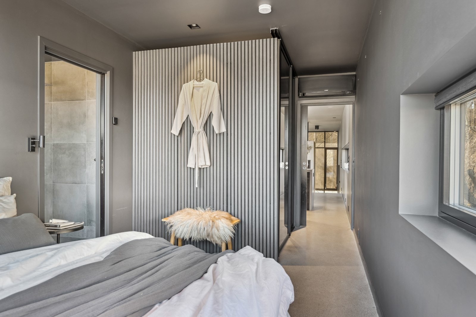 Overflatene er også her elegante og mørke, og betonggulvet går igjen også på soverommet. Galleribilde