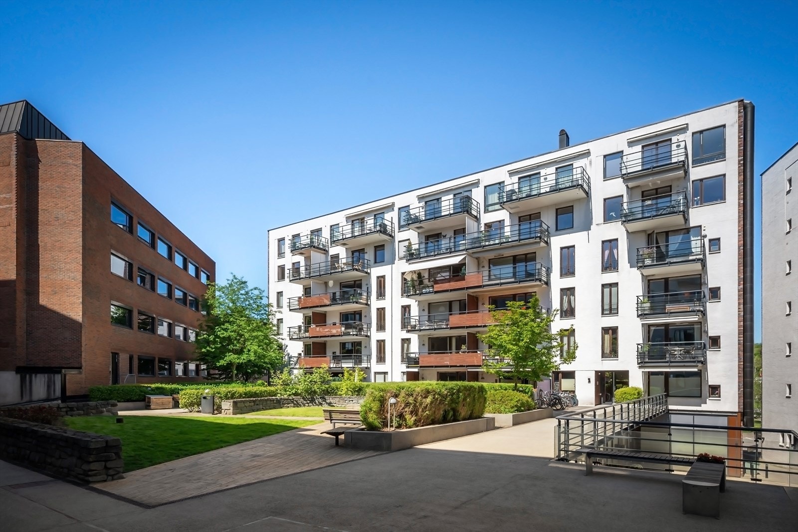 Fasade/bakgård med trivelige grøntarealer og sittegrupper Galleribilde