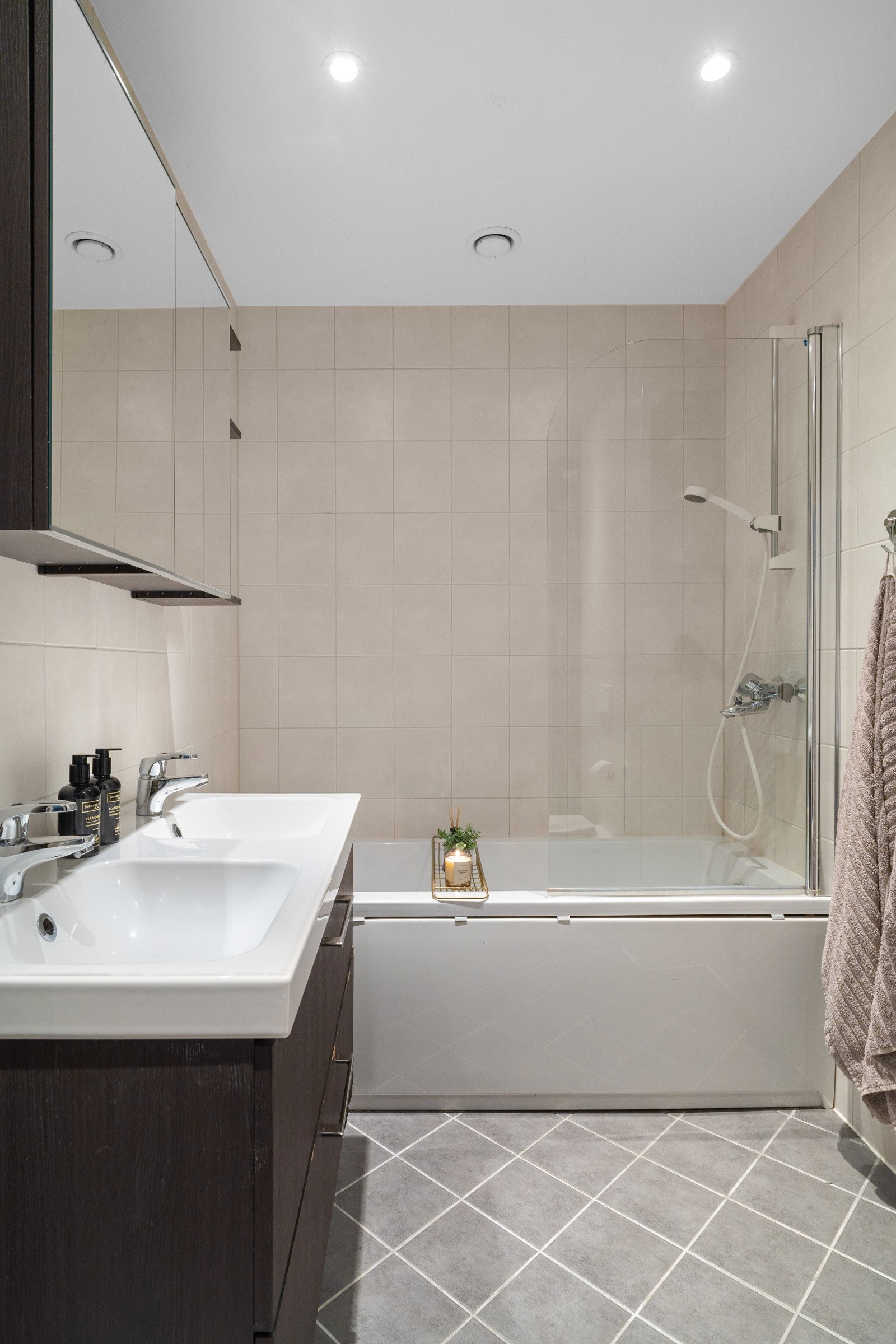 Badet er utstyrt med dobbel servant-skap, speilskap og badekar med dusjløsning. Galleribilde