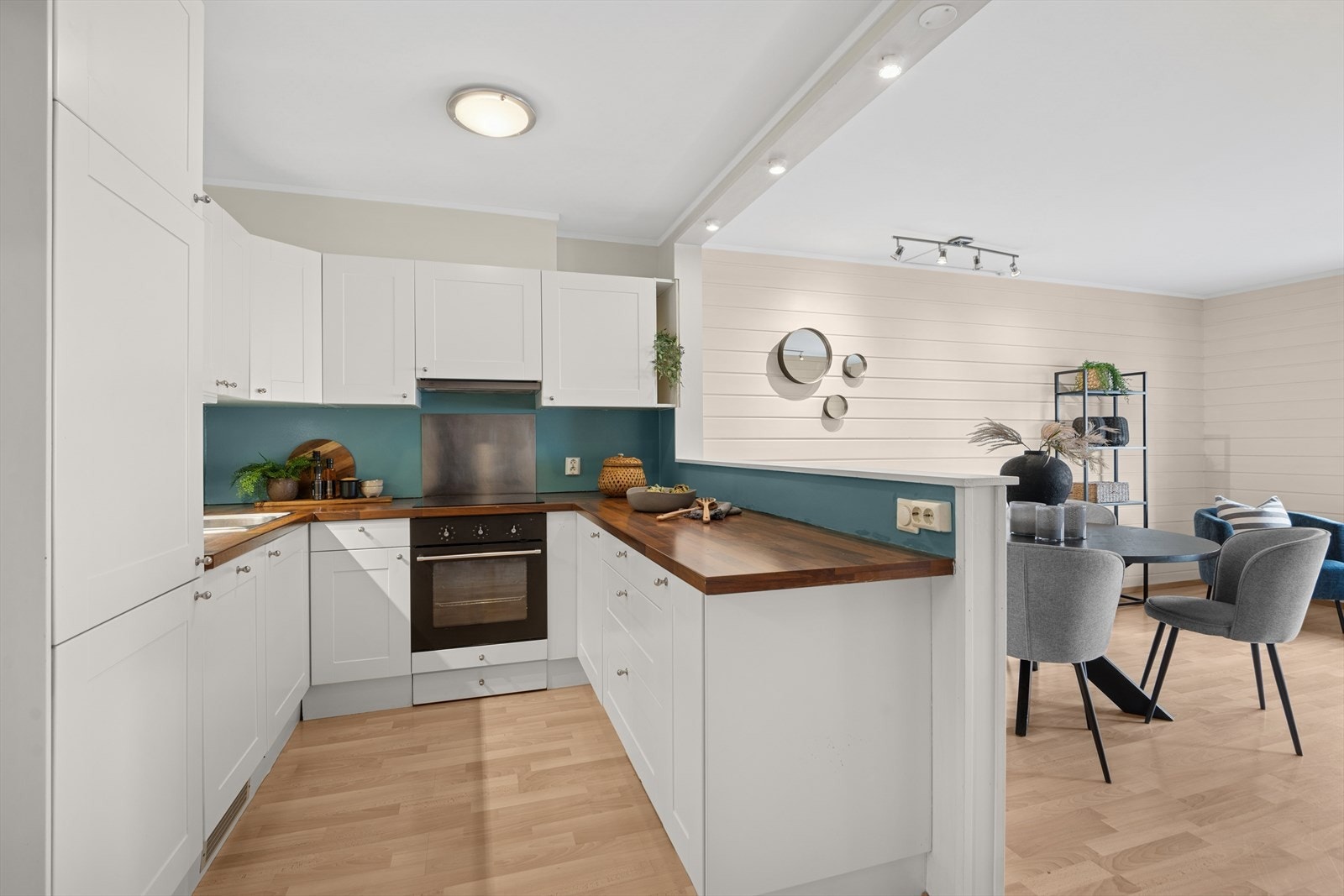 Kjøkkeninnredningen har profilerte hvite fronter og laminat benkeplate. Galleribilde