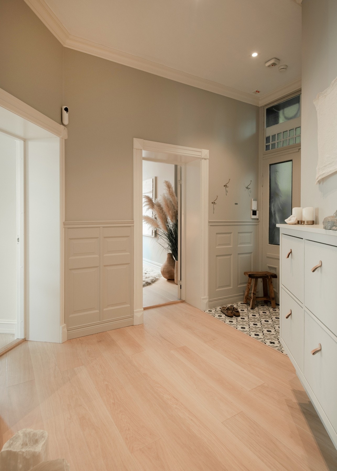 Romslig hall som gir et elegant førsteinntrykk med blant annet klassiske listverk, profilerte innerdører og kvalitetsmaterialer understreker den tidløse elegansen Galleribilde