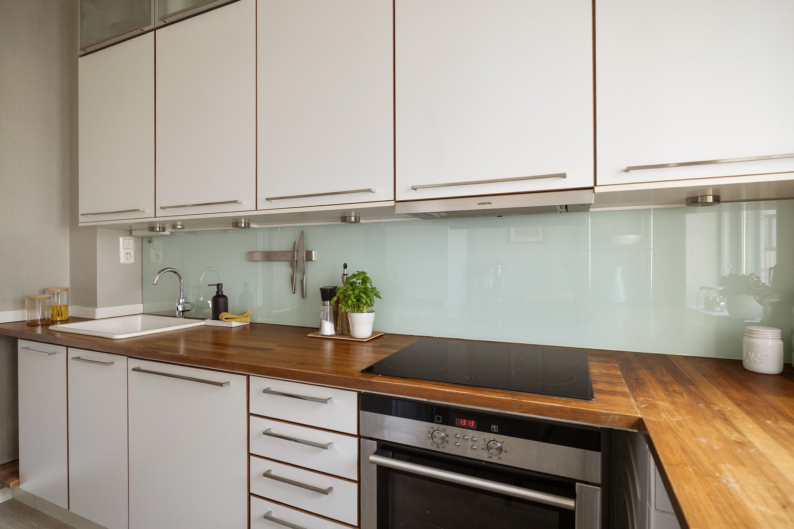 Lys og tidløs kjøkkeninnredning med flott valnøtt benkeplate. Galleribilde