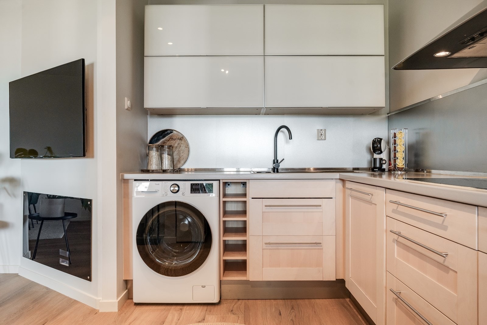 Kjøkken i åpen løsning , med opplegg for vaskemaskin og masser av skapplass. Galleribilde