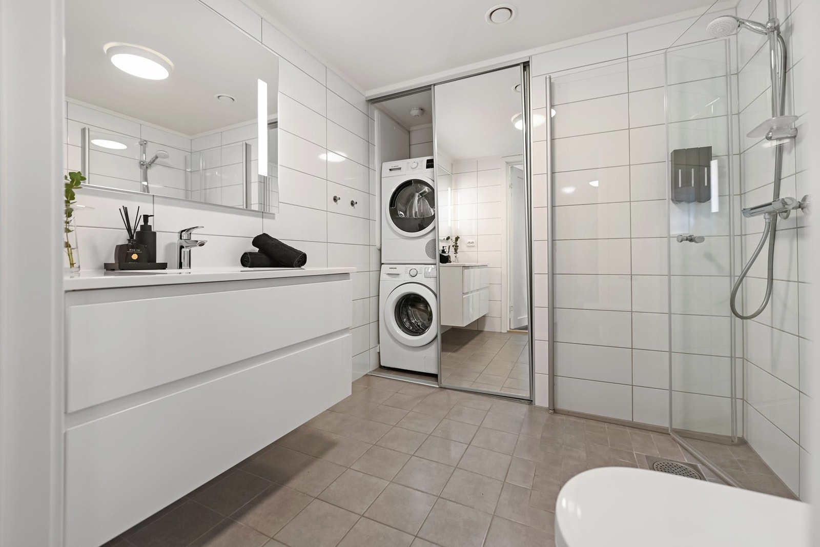 Vaskeromsdelen er praktisk skjult bak skyvedører på baderommet Galleribilde