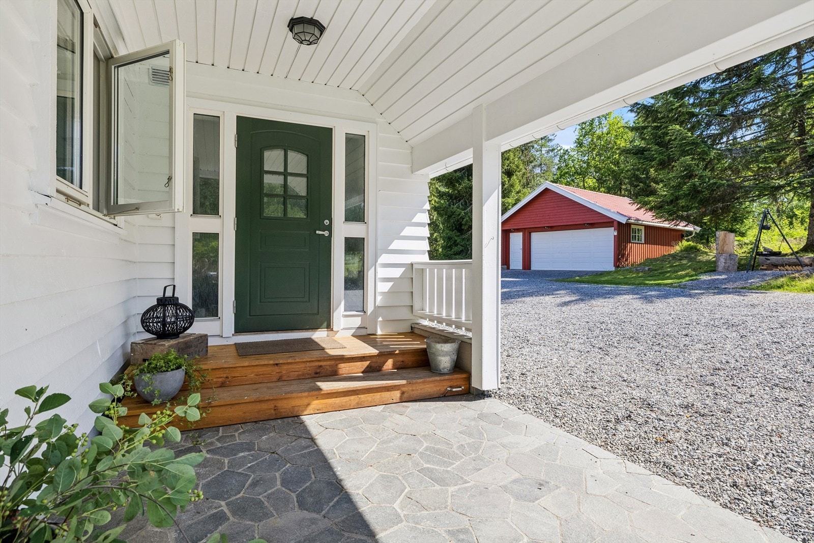 Innbydende, overbygd inngangsparti med varmekabler i skiferplatting Galleribilde