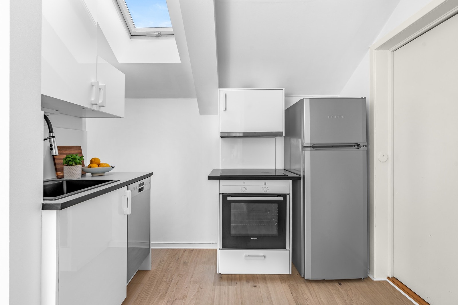 Kjøkken med åpen løsning mot stue. Kjøkkeninnredning med slette fronter. Benkeplater av laminat. Nedfelt oppvaskkum i kompositt med ett-greps armatur. Galleribilde