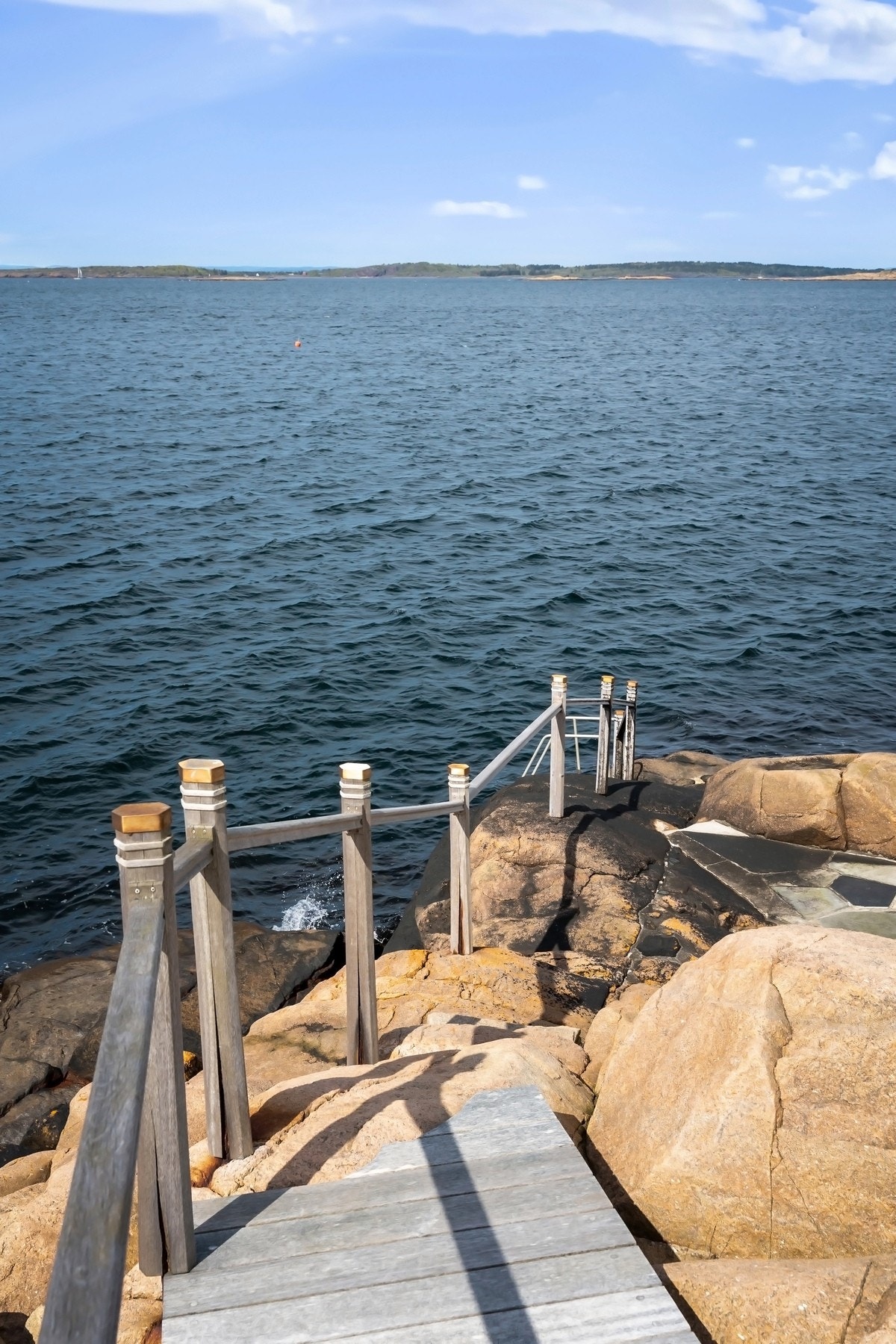 Svaberg med badetrapp ned til sjøen. Galleribilde