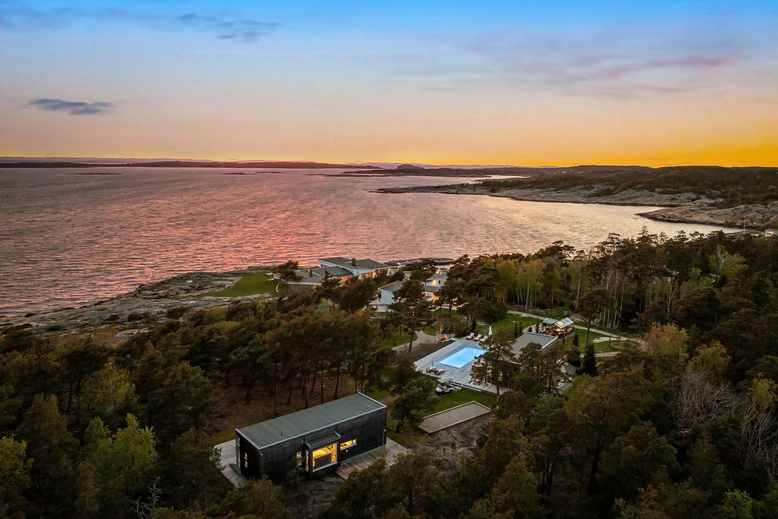 Oversiktbilde, kveld viser 2 stk gjesteboliger i bakkant av eiendommen bygget i 2014. Galleribilde