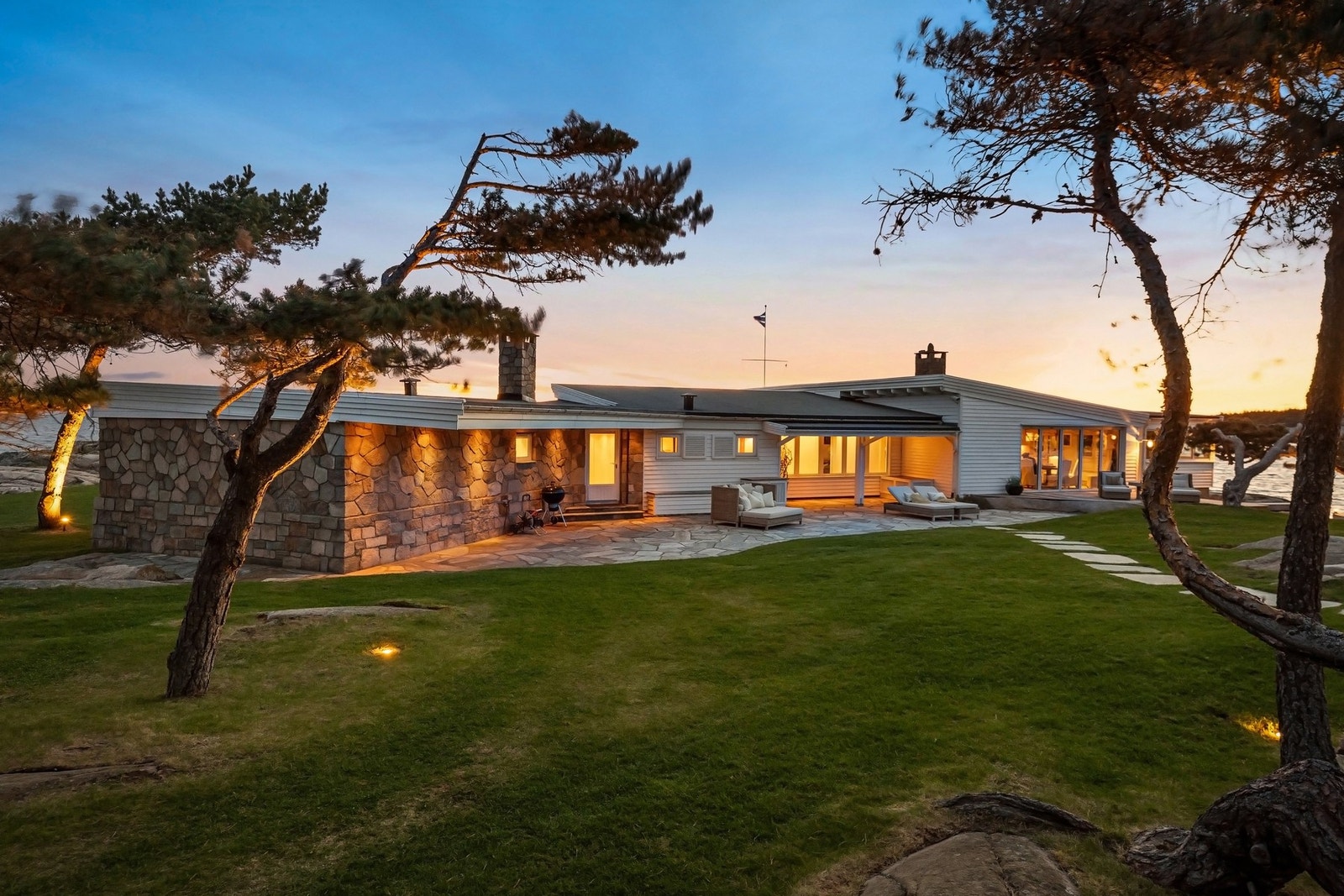 Vakker parkmessig hage bak hovedhuset med utebelysning og stedegen vegetasjon. Galleribilde