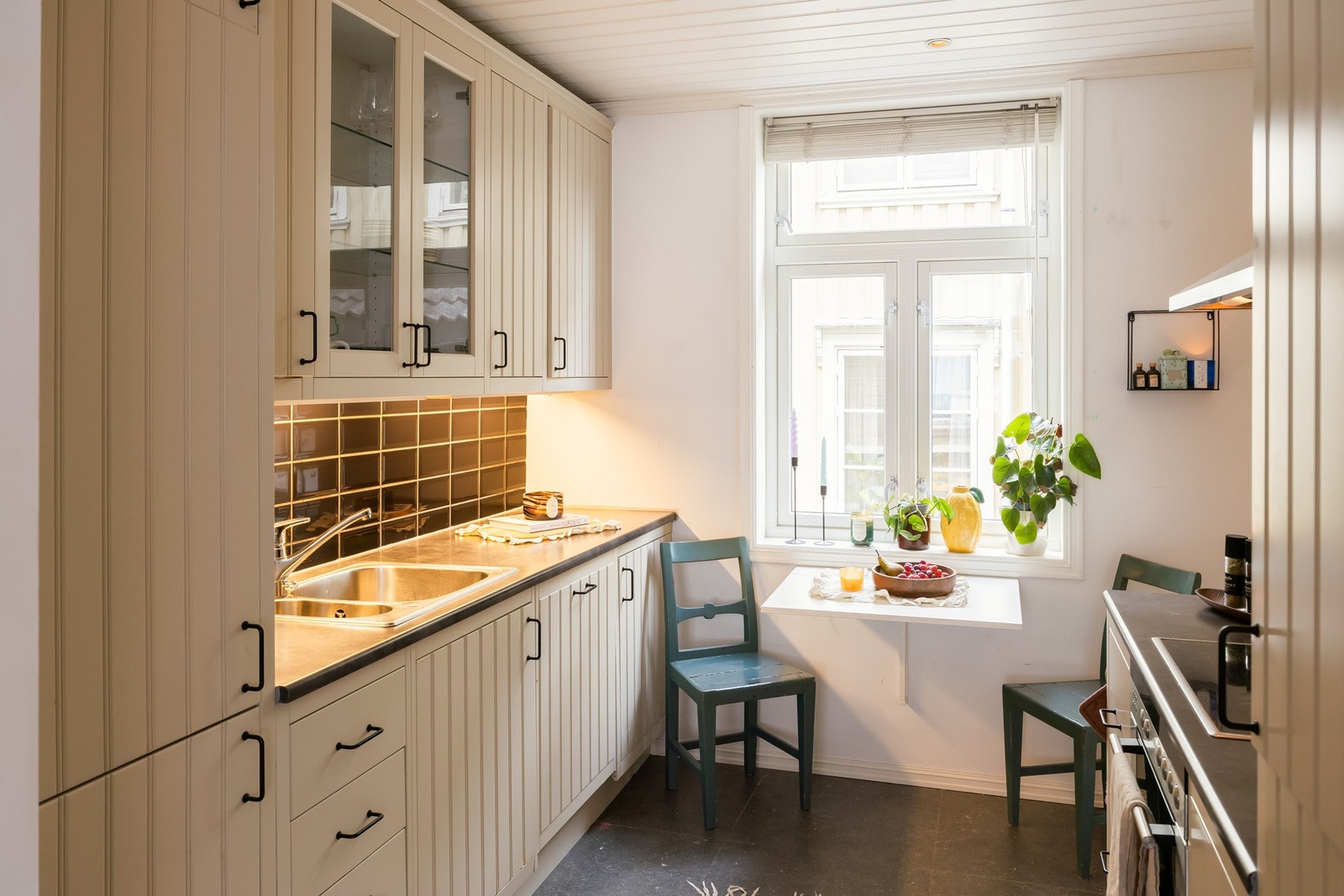 Lyst kjøkken med rikelig benk- og skapplass, integrerte hvitevarer (komfyr, platetopp, oppvaskmaskin og kjøleskap) og downlights belysning. Galleribilde