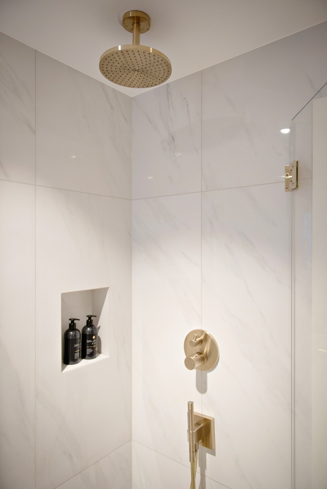 Dusjhjørne med innfellbare glassdører, samt integrert armatur, takdusj og hånddusj Galleribilde