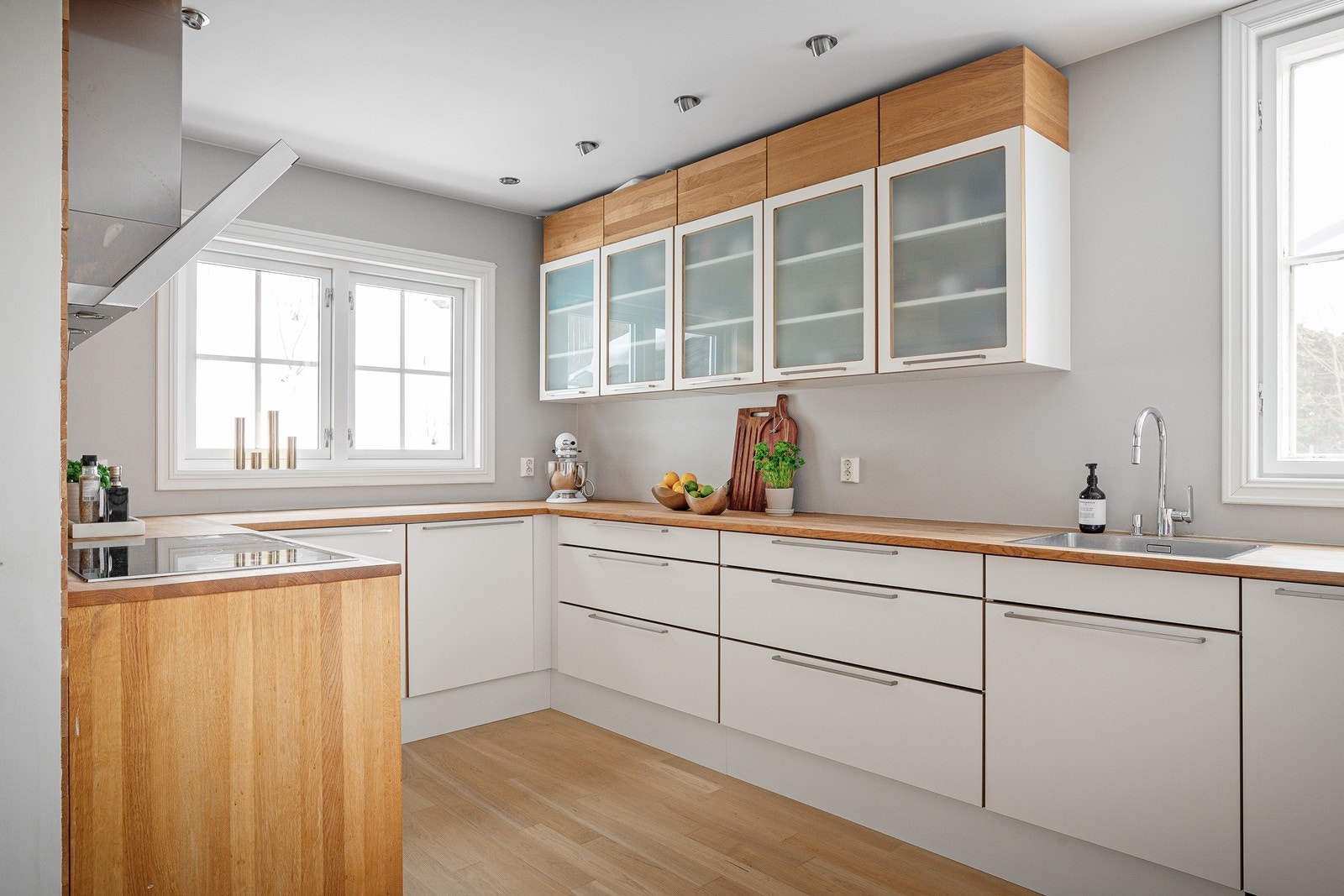 Stort, familievennlig kjøkken med glatte fronter, metallhåndtak og heltre benkeplater Galleribilde