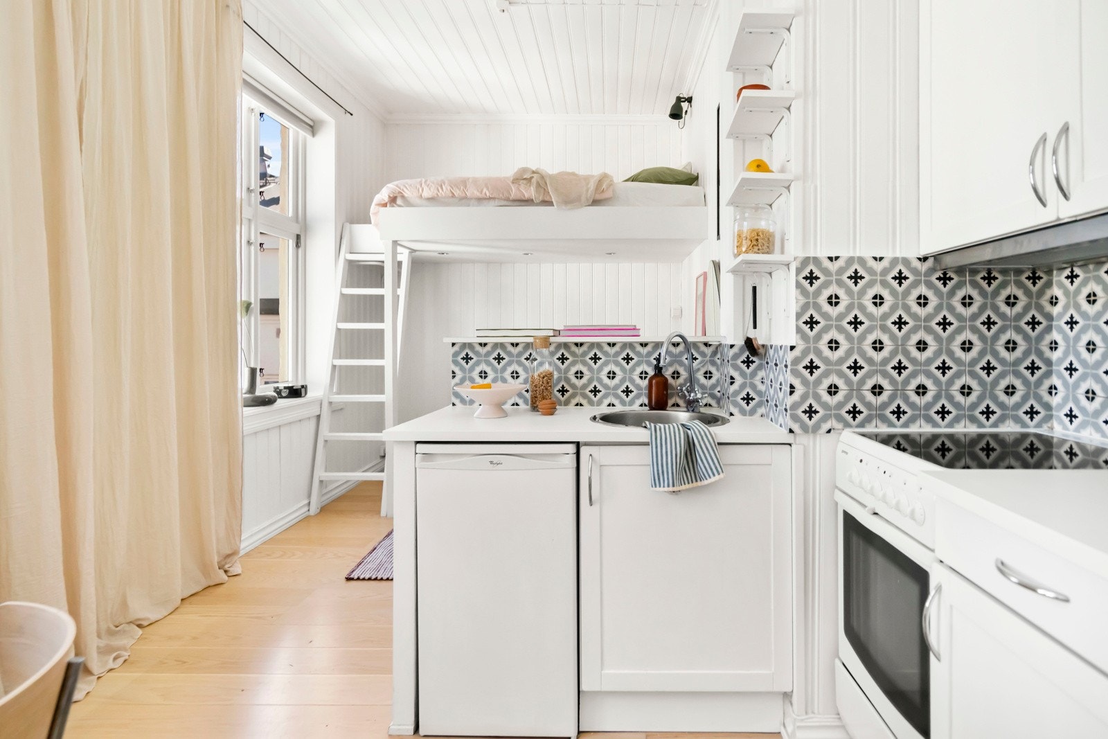 Åpen stue- og kjøkkenløsning med profilerte, malte fronter. Galleribilde